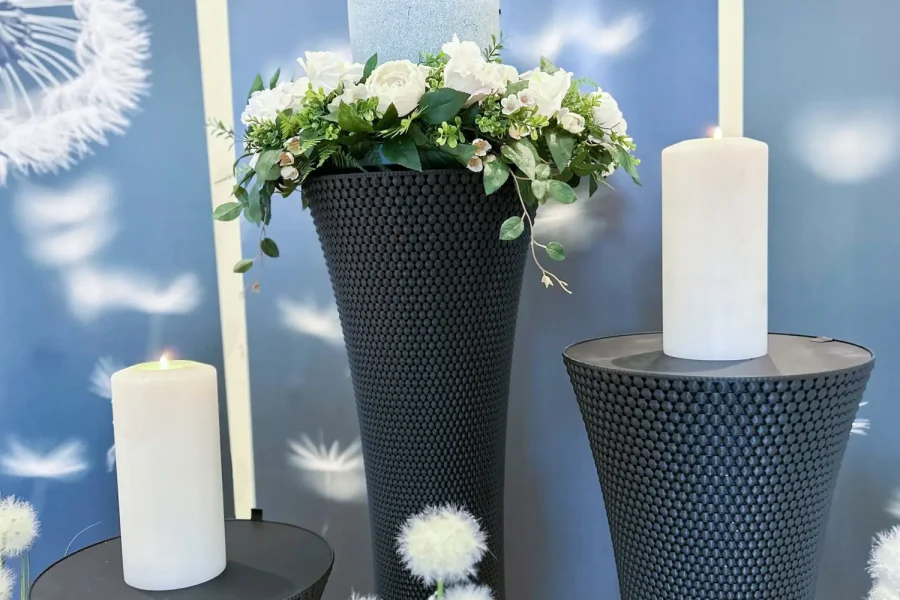 Hochwertige Urnenschmuck mit modernen schwarzen Standvasen und weißen Blumen, ideale Bestattungsdekoration, einfühlsame Trauerfloristik von Horst Fritz Bestattungen.