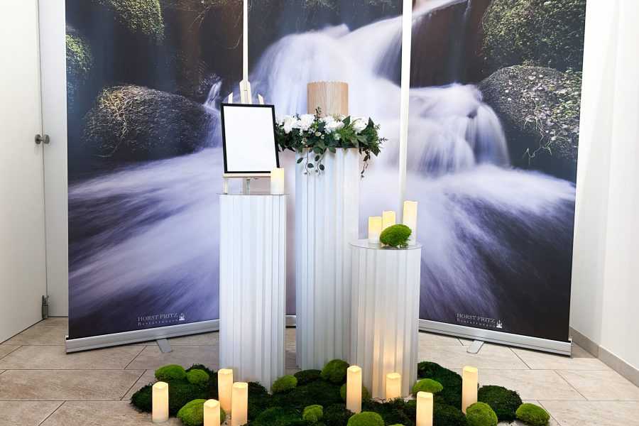 Dekorierter Erinnerungsplatz mit Kerzen und Blumen