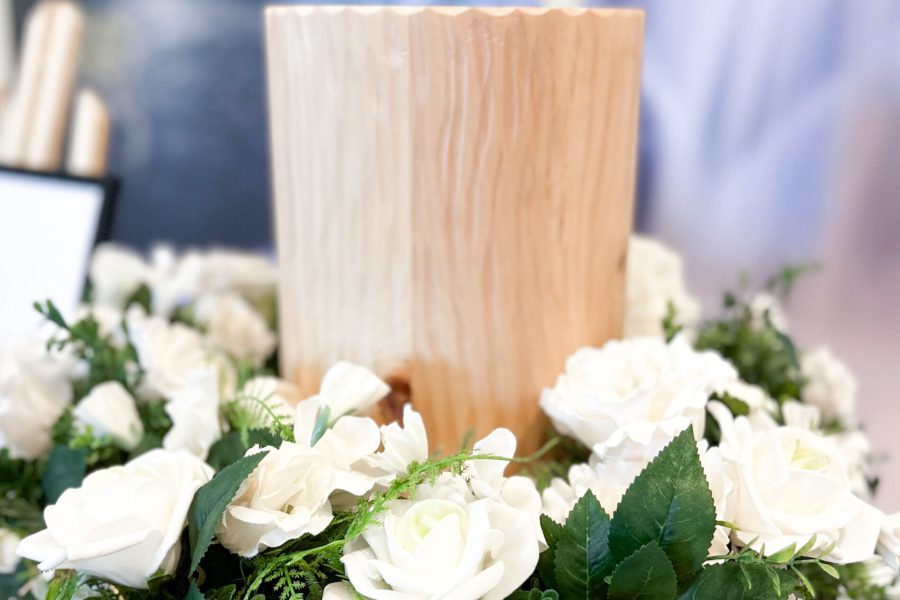 Holzurne mit Blumenschmuck